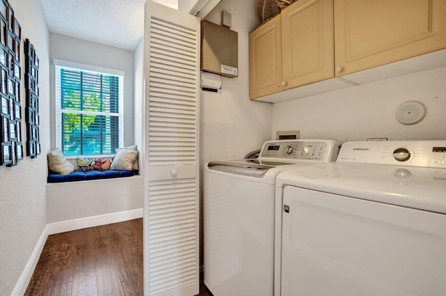 washroom featuring cabinet space, washing machine and clothes dryer, baseboards, and wood finished floors