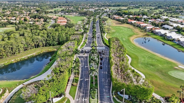 aerial view of property's location with a large body of water, a golf course, and nearby suburban area