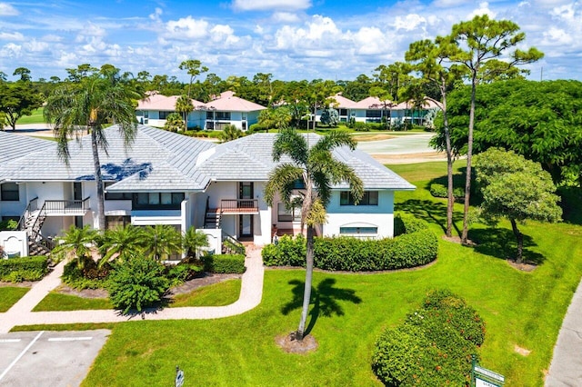 3980 Quail Ridge Dr Egret, Unit Egret, Boynton Beach, FL 33436 - view of front of home featuring a residential view, stucco siding, a front yard, a balcony, and uncovered parking