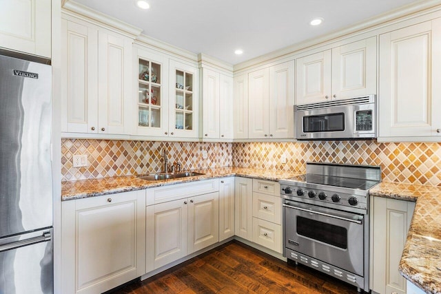 3980 Quail Ridge Dr Egret, Unit Egret, Boynton Beach, FL 33436 - kitchen with light stone counters, appliances with stainless steel finishes, a sink, dark wood-type flooring, and glass insert cabinets