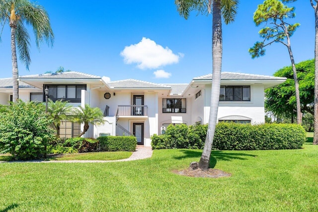3980 Quail Ridge Dr Egret, Unit Egret, Boynton Beach, FL 33436 - view of front facade featuring a front lawn, a balcony, and stucco siding