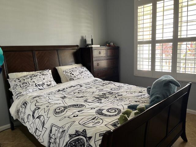 bedroom with baseboards and tile patterned flooring