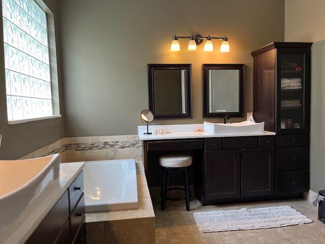 full bathroom featuring a garden tub and vanity