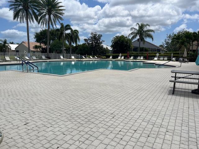 community pool with fence and a patio area
