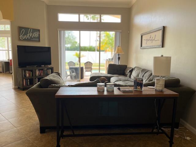 tiled living room featuring crown molding