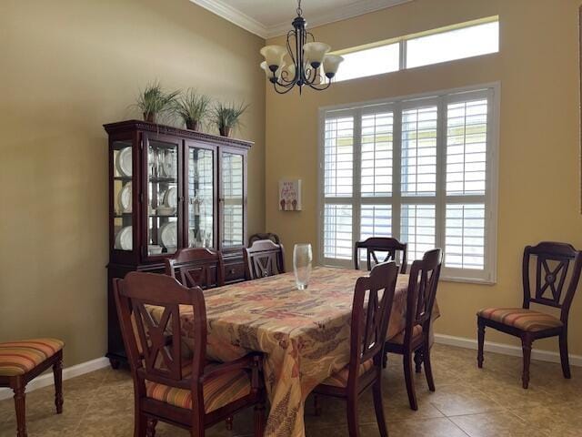 dining area with an inviting chandelier, baseboards, crown molding, and a wealth of natural light