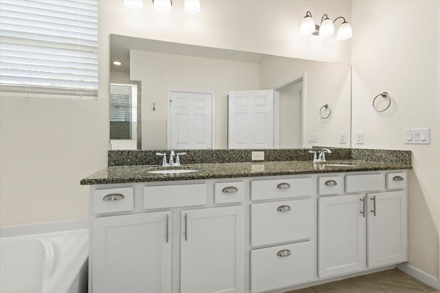 12133 SW Aventino Dr, Port Saint Lucie, FL 34987 - full bath featuring double vanity, tile patterned flooring, and a tub to relax in