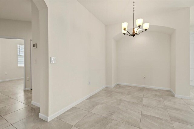 12133 SW Aventino Dr, Port Saint Lucie, FL 34987 - unfurnished dining area with a chandelier, arched walkways, and baseboards