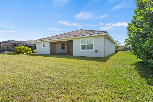 12133 SW Aventino Dr, Port Saint Lucie, FL 34987 - back of house featuring a yard, a tiled roof, and stucco siding