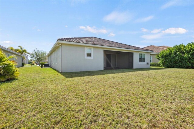 12133 SW Aventino Dr, Port Saint Lucie, FL 34987 - rear view of house with a lawn, a tile roof, ceiling fan, and stucco siding
