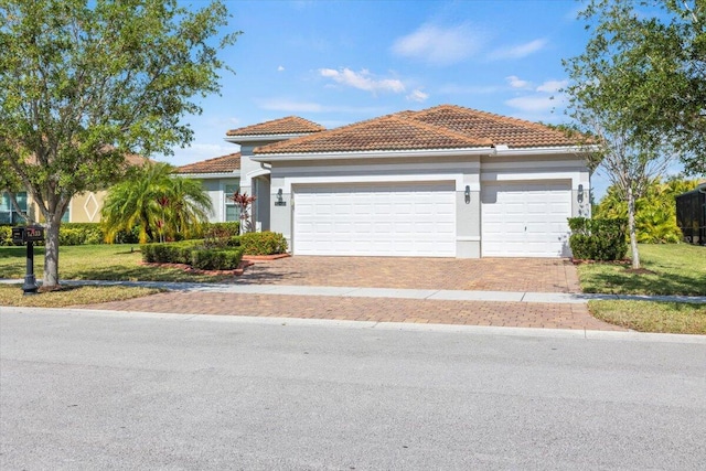 12133 SW Aventino Dr, Port Saint Lucie, FL 34987 - mediterranean / spanish-style home featuring a tiled roof, a garage, decorative driveway, stucco siding, and a front lawn