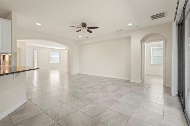 12133 SW Aventino Dr, Port Saint Lucie, FL 34987 - unfurnished living room with arched walkways, ceiling fan, light tile patterned floors, recessed lighting, and baseboards