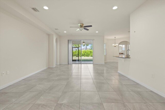12133 SW Aventino Dr, Port Saint Lucie, FL 34987 - unfurnished living room with a chandelier, a ceiling fan, recessed lighting, baseboards, and arched walkways