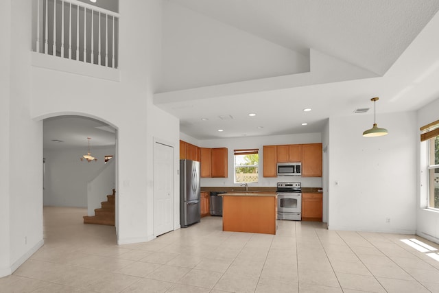 kitchen with visible vents, light tile patterned floors, a center island, and stainless steel appliances