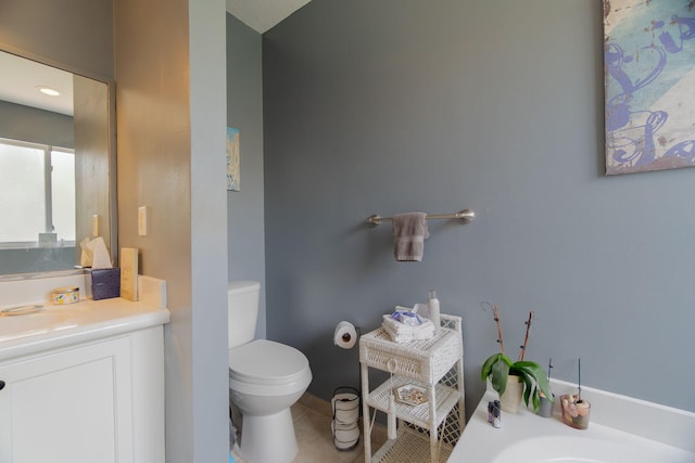 bathroom with vanity, tile patterned floors, a washtub, and toilet