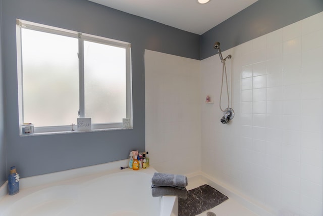 bathroom with a bathing tub and a tile shower
