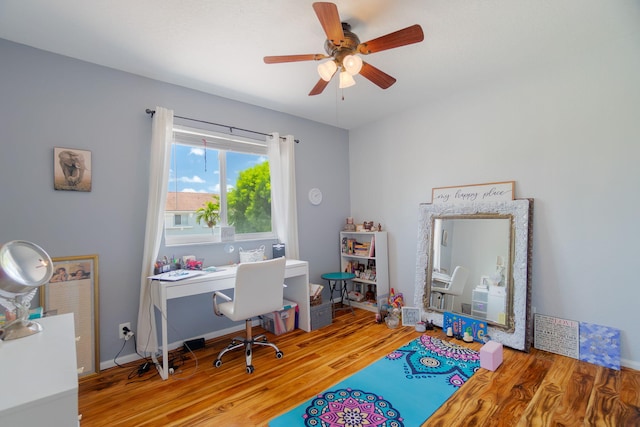 office featuring a ceiling fan, baseboards, and wood finished floors