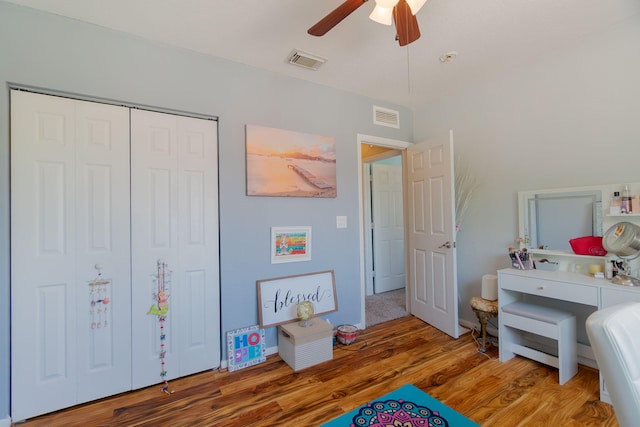 bedroom featuring a ceiling fan, a closet, wood finished floors, and visible vents