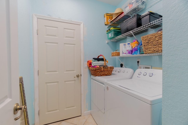 laundry area featuring light tile patterned floors, laundry area, and washing machine and clothes dryer
