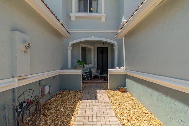doorway to property featuring a tiled roof and stucco siding