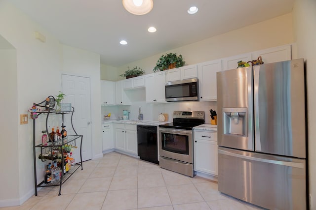 kitchen with white cabinets, stainless steel appliances, recessed lighting, and light tile patterned flooring
