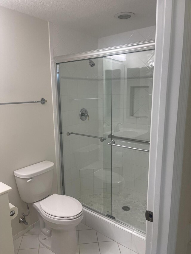 7727 Southampton Ter Unit 305, Tamarac, FL 33321 - full bath featuring toilet, a textured ceiling, tile patterned flooring, a shower stall, and vanity