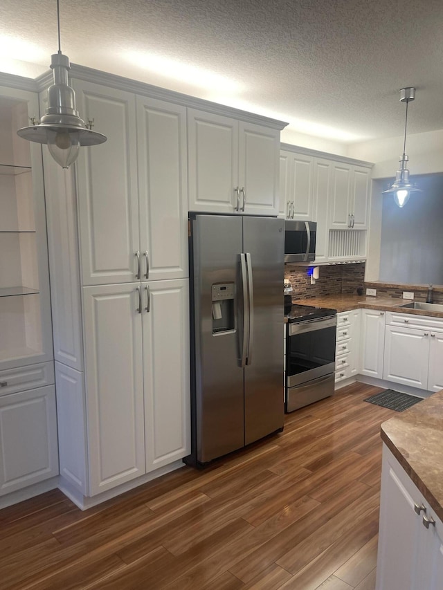 7727 Southampton Ter Unit 305, Tamarac, FL 33321 - kitchen featuring stainless steel appliances, dark wood-type flooring, white cabinets, pendant lighting, and a textured ceiling