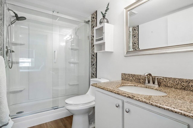 full bathroom with vanity, wood finished floors, toilet, and a shower stall