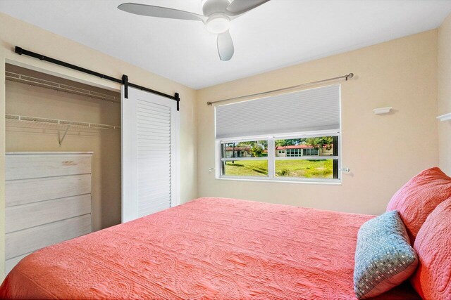 bedroom with a ceiling fan and a barn door