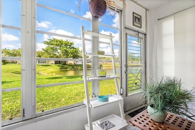 sunroom / solarium featuring a water view