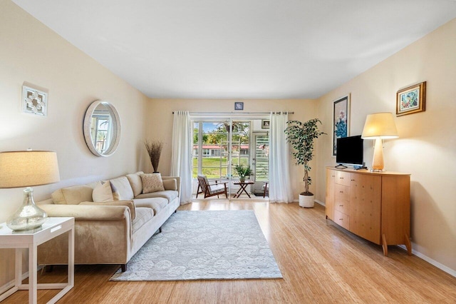 living room with baseboards and light wood finished floors