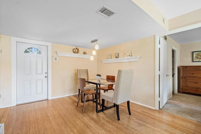 dining area featuring visible vents, baseboards, and light wood-type flooring