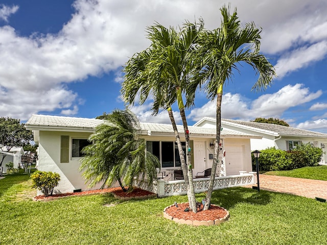 ranch-style home with an attached garage, driveway, stucco siding, and a front yard