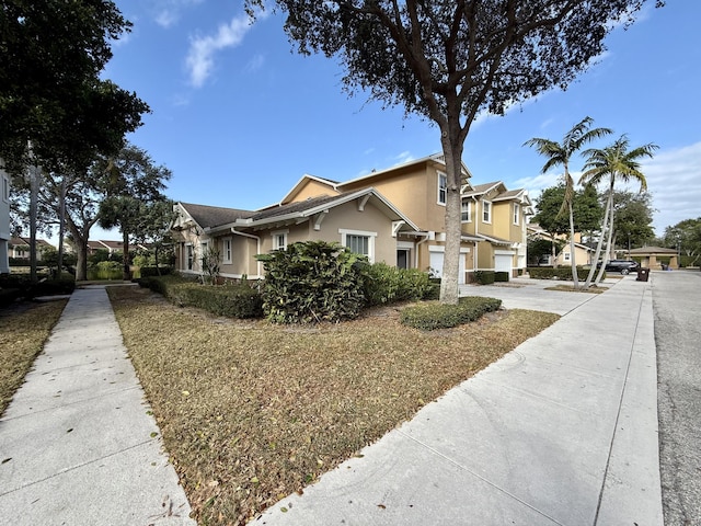 963 Marina Del Ray Ln Unit 1, West Palm Beach, FL 33401 - view of home's exterior featuring a garage, stone siding, stucco siding, driveway, and a residential view