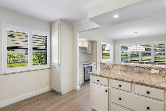 kitchen with wine cooler, light stone countertops, baseboards, light wood-style floors, and hanging light fixtures