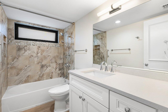 full bath with vanity, visible vents, wood finished floors, toilet, and bathtub / shower combination