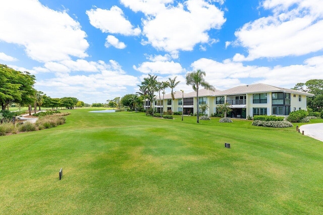 view of community featuring a water view, a yard, and golf course view