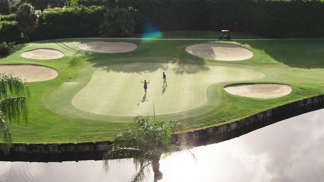 view of home's community with a water view and view of golf course