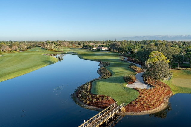 drone / aerial view with a water view and view of golf course