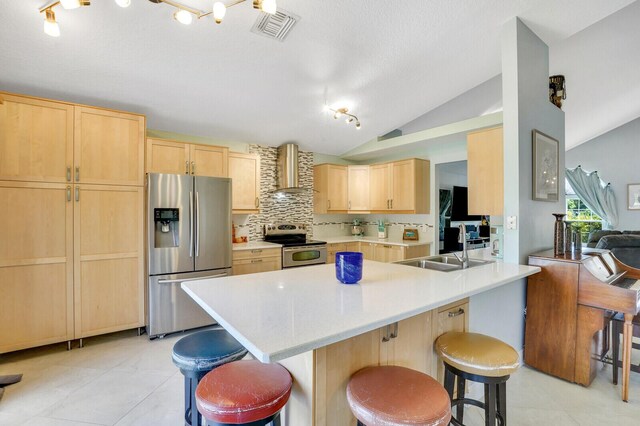 9681 Pine Trail Ct, Lake Worth, FL 33467 - kitchen with appliances with stainless steel finishes, light brown cabinets, wall chimney range hood, vaulted ceiling, and a breakfast bar area