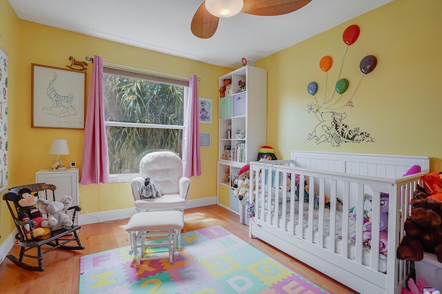 9681 Pine Trail Ct, Lake Worth, FL 33467 - bedroom featuring a nursery area, wood finished floors, and ceiling fan