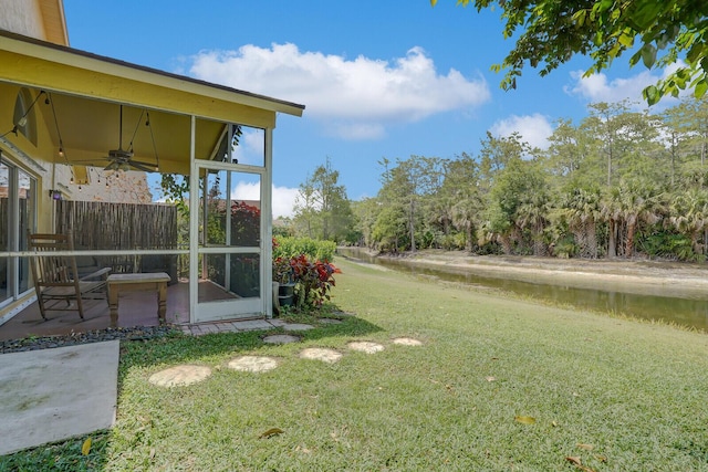 9681 Pine Trail Ct, Lake Worth, FL 33467 - view of grassy yard featuring a sunroom, ceiling fan, a water view, and a patio