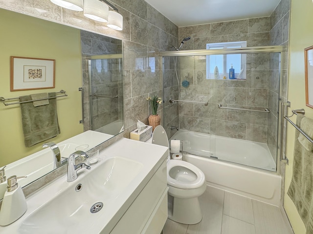 bathroom featuring vanity, bath / shower combo with glass door, tile patterned flooring, and toilet