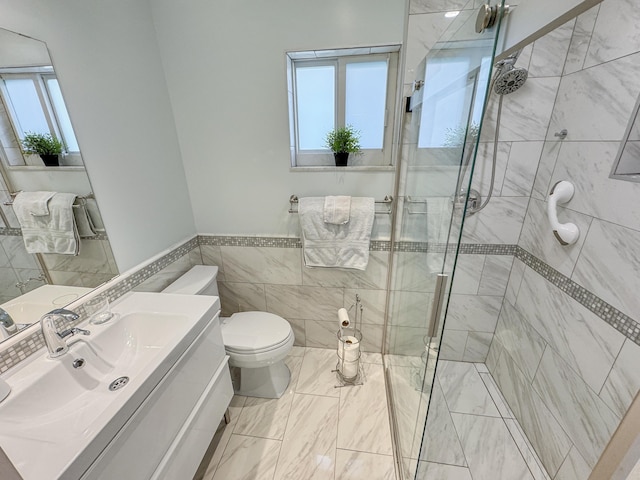 full bath featuring vanity, marble finish floor, toilet, tile walls, and a stall shower