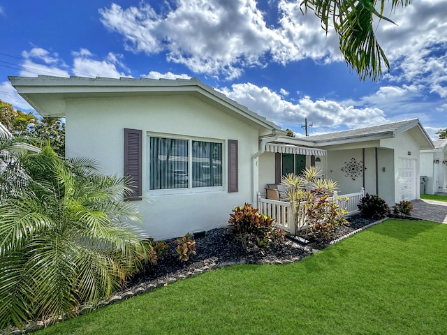 view of front facade featuring a porch, an attached garage, a front lawn, and stucco siding