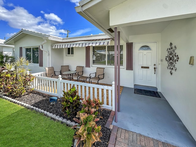 property entrance featuring stucco siding and a porch