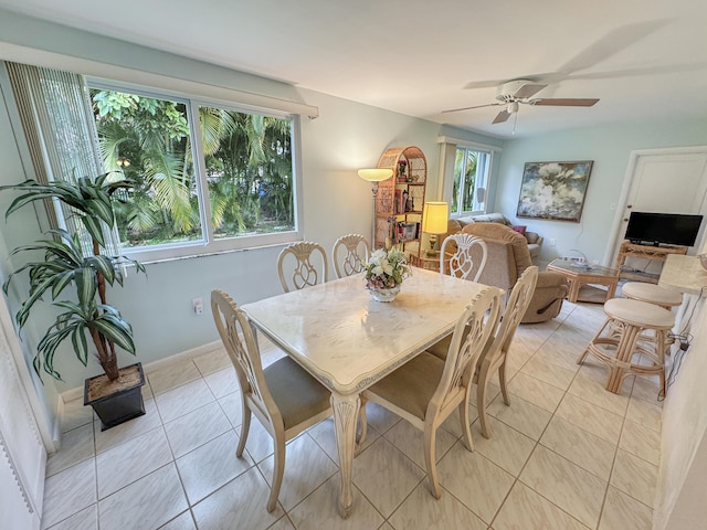 dining space featuring light tile patterned flooring, ceiling fan, plenty of natural light, and baseboards