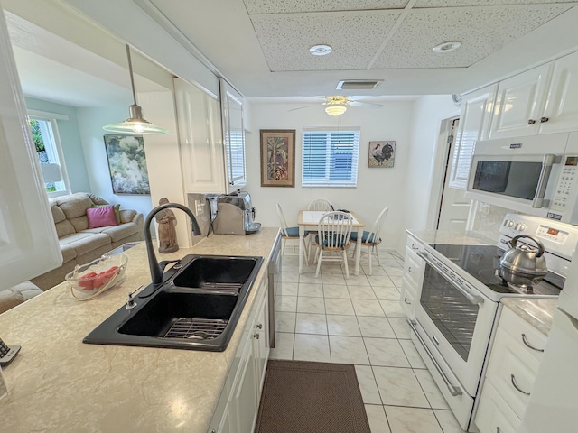 kitchen featuring visible vents, white appliances, light countertops, white cabinets, and a sink