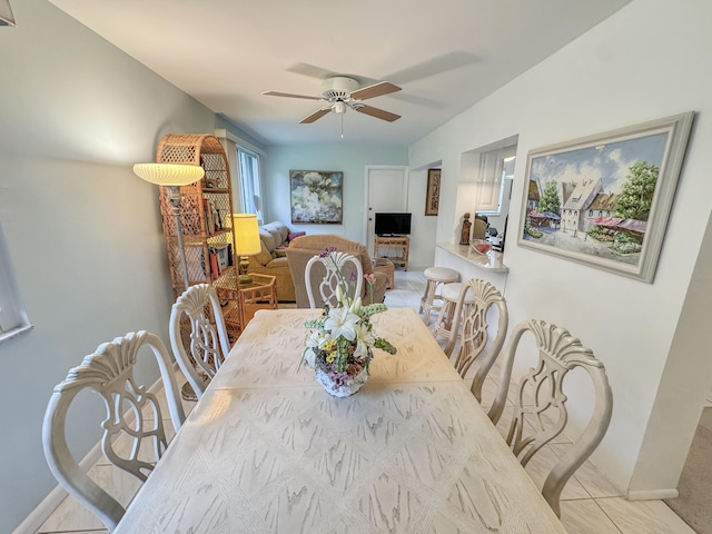 dining space with light tile patterned floors, ceiling fan, and baseboards