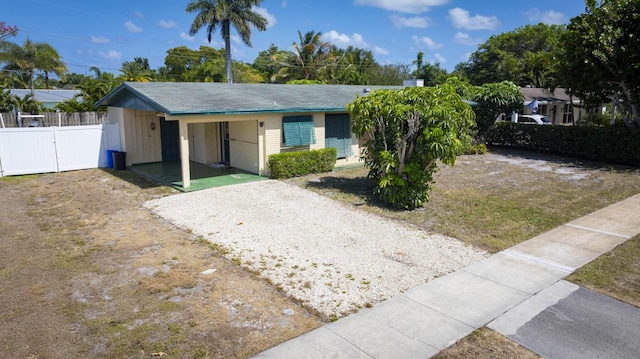 view of front facade featuring a gate, fence, and driveway